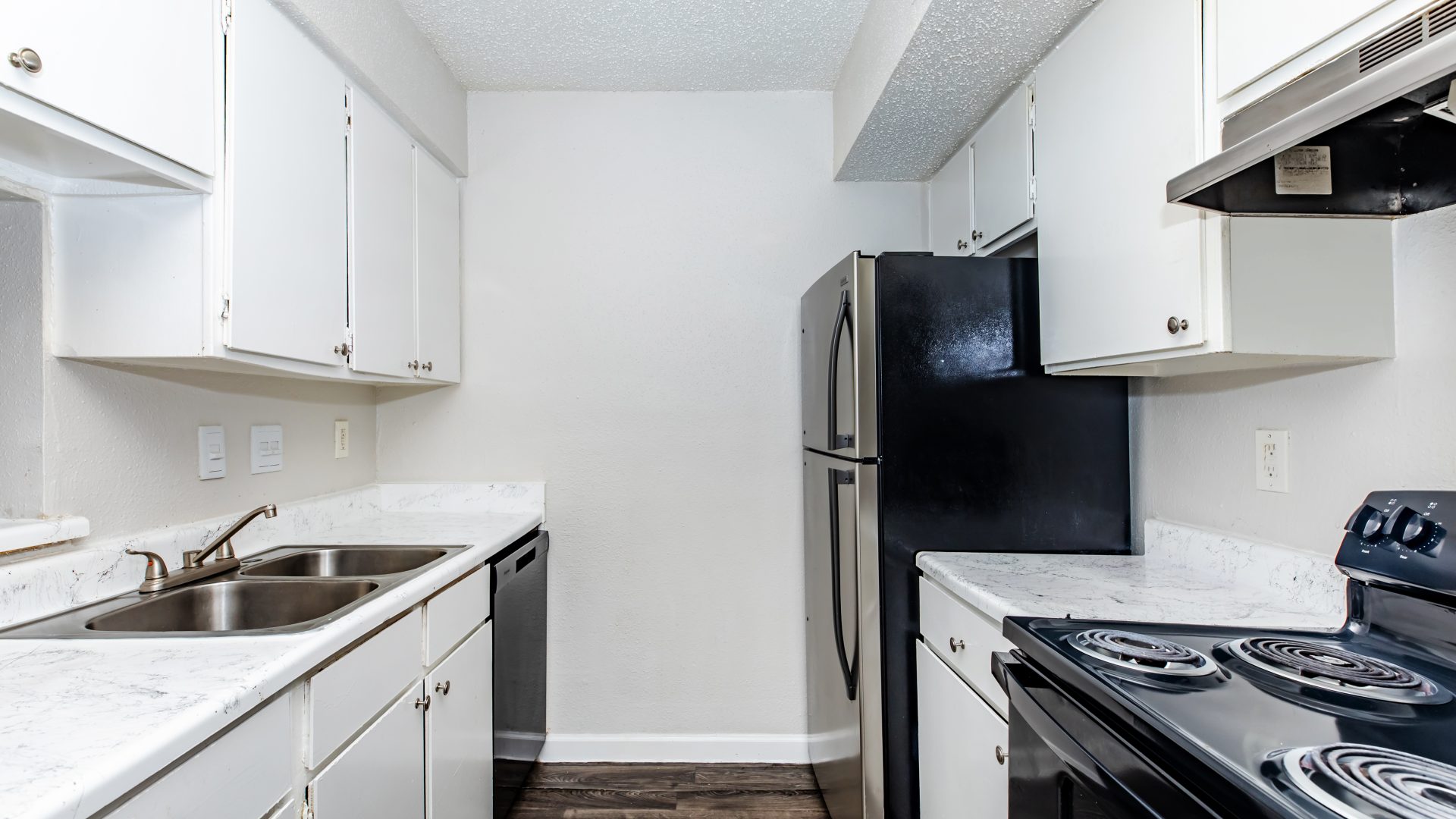 a kitchen with a stove, refrigerator, sink and cabinets